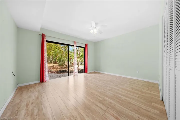 Empty room with light wood finished floors, baseboards, and ceiling fan