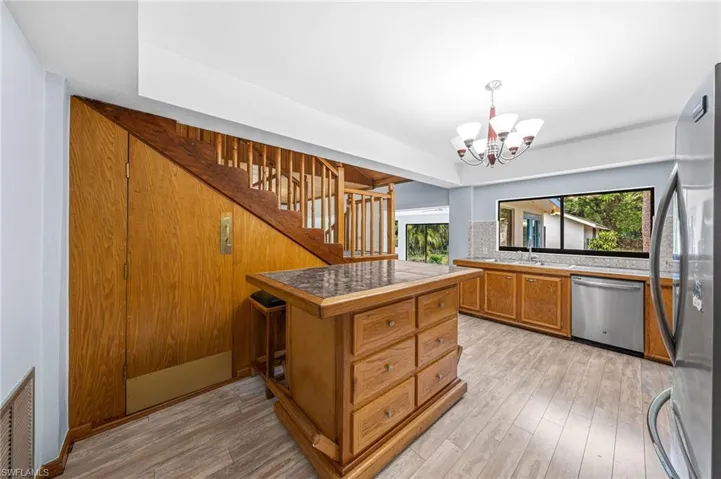 Kitchen featuring appliances with stainless steel finishes, light wood finished floors, an inviting chandelier, and visible vents