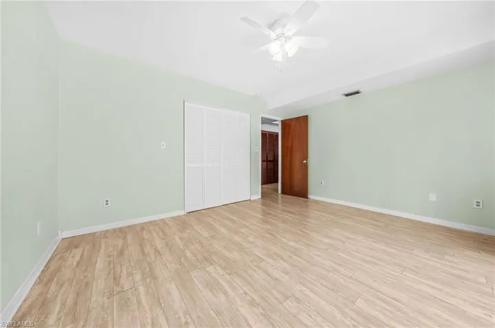 Unfurnished room featuring light wood-style flooring, baseboards, visible vents, and ceiling fan