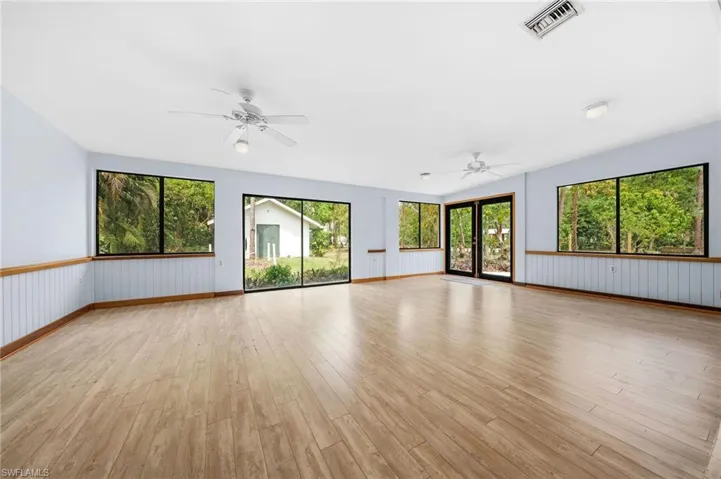 Spare room with light wood-style floors, ceiling fan, baseboards, and visible vents
