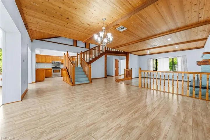 Living area with wooden ceiling, a chandelier, visible vents, light wood finished floors, and vaulted ceiling with beams