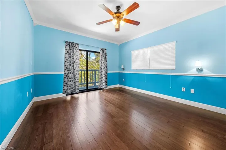 Empty room featuring baseboards, a ceiling fan, ornamental molding, and wood finished floors