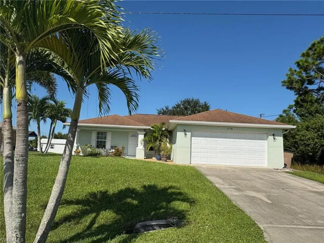 Single story home featuring stucco siding, concrete driveway, an attached garage, and a front lawn