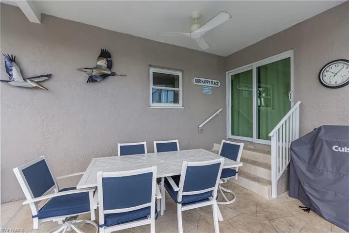 View of patio featuring a ceiling fan, entry steps, a grill, and outdoor dining space