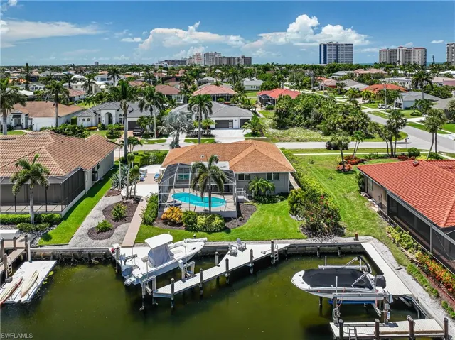 Aerial perspective of suburban area with a pool area and a nearby body of water