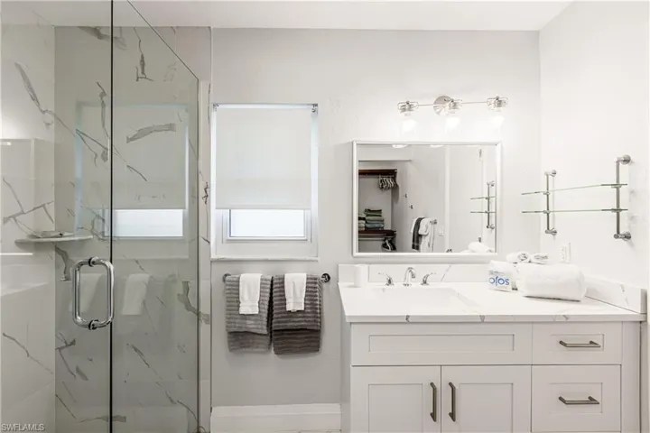 Bathroom with a marble finish shower and vanity