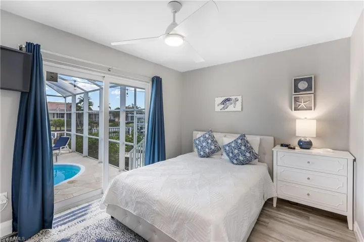 Bedroom with access to exterior, wood finished floors, and a ceiling fan