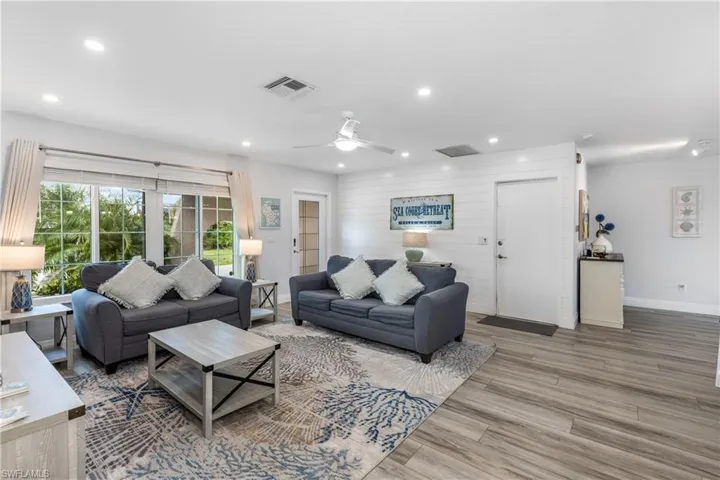Living area with wood finished floors, a ceiling fan, and recessed lighting