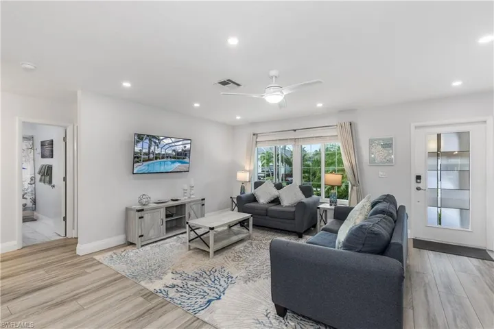 Living room featuring ceiling fan, light wood-style flooring, and recessed lighting