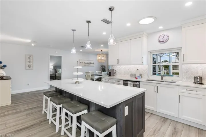 Kitchen with a kitchen island, white cabinets, light countertops, and recessed lighting
