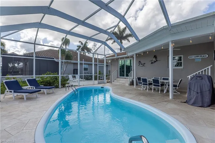 Outdoor pool featuring entry steps, a patio area, a lanai, and grilling area