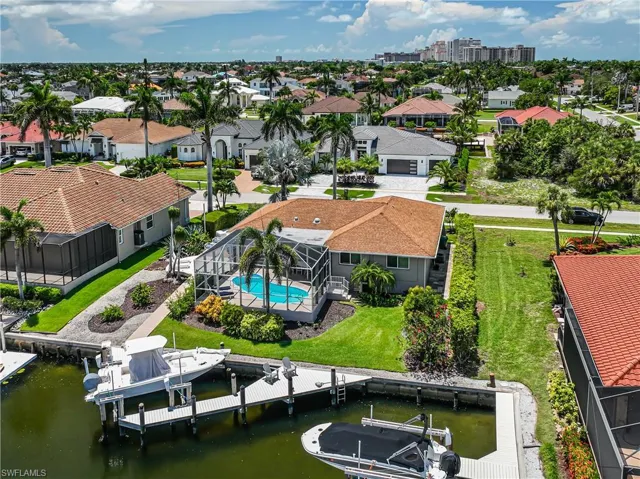 Drone / aerial view of a pool area and a nearby body of water