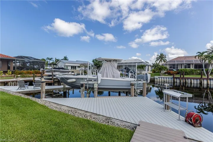 Dock with boat lift, a water view, and a residential view