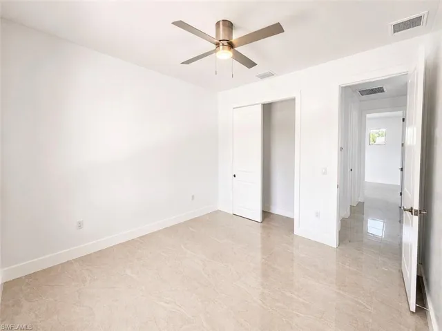 Neutral-toned tiled flooring throughout, complemented by a ceiling fan with integrated lighting