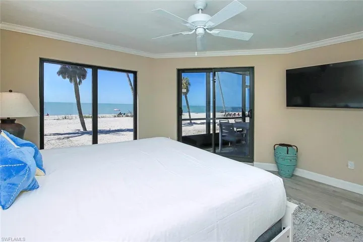 Bedroom with access to exterior, ornamental molding, wood finished floors, and ceiling fan
