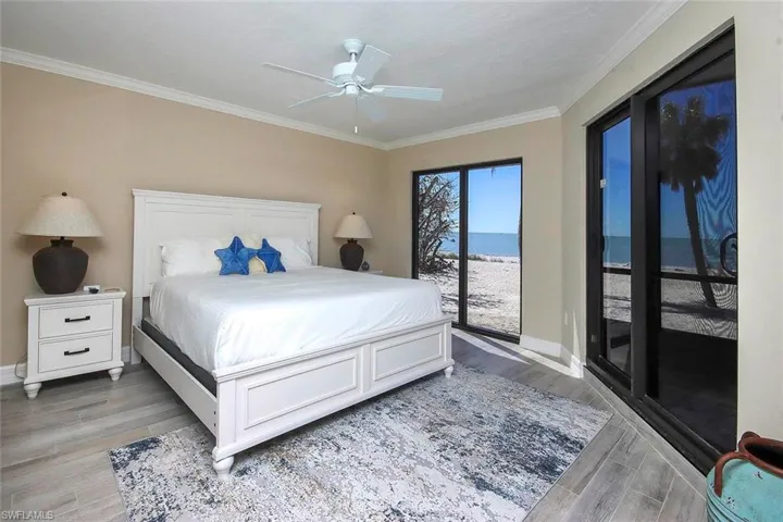 Bedroom featuring access to exterior, light wood-style flooring, ornamental molding, and a ceiling fan