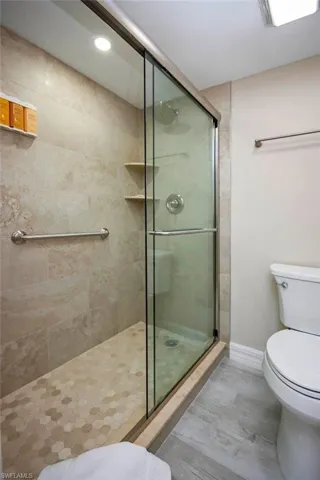 Full bath featuring a stall shower, wood finished floors, and recessed lighting