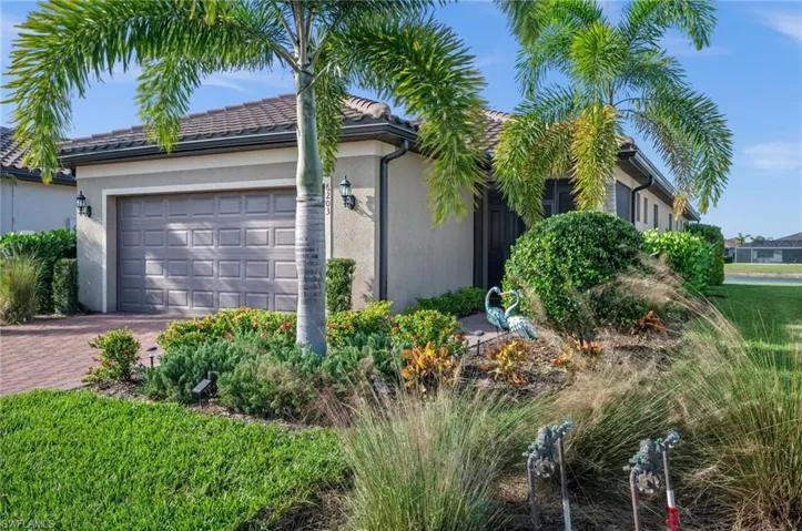 View of side of property with stucco siding, an attached garage, and decorative driveway