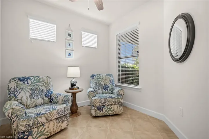 Sitting room with a ceiling fan and light tile patterned flooring
