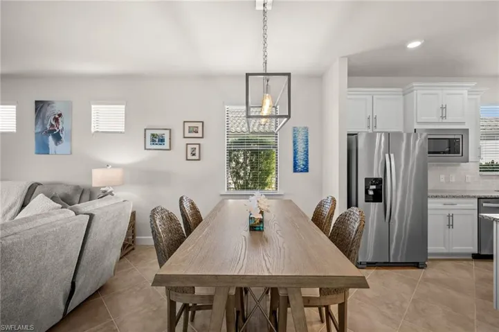 Dining area featuring light tile patterned floors, recessed lighting, and a chandelier