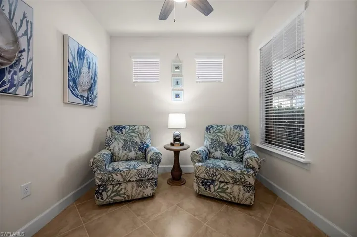 Sitting room featuring healthy amount of natural light, tile patterned flooring, and ceiling fan