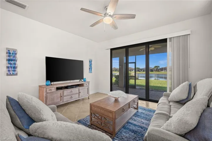 Living room with light tile patterned flooring and a ceiling fan