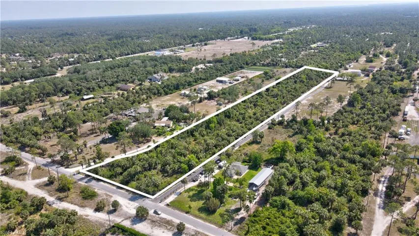 Birds eye view of property featuring a wooded view