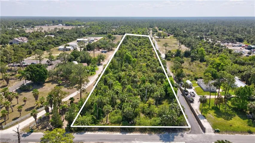 Birds eye view of property with a wooded view