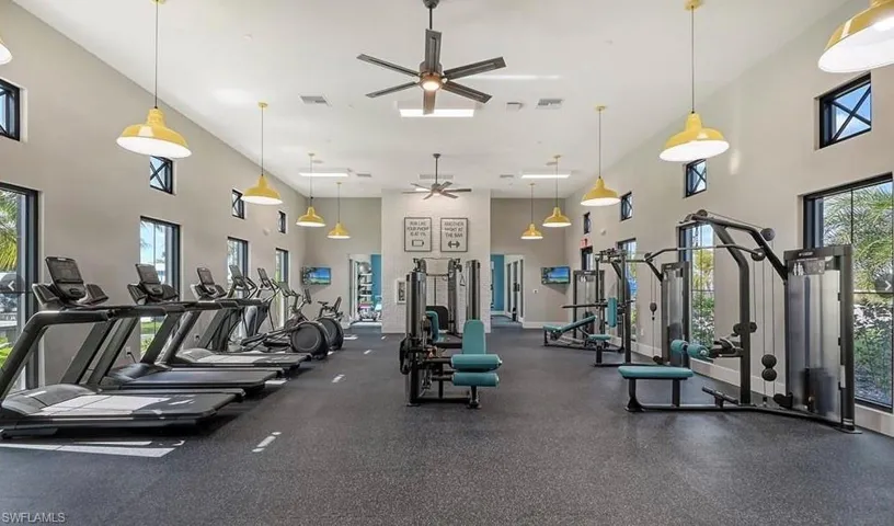 Gym featuring a high ceiling and a ceiling fan