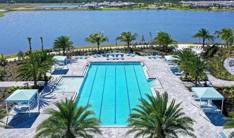 Community pool featuring a water view and a patio area