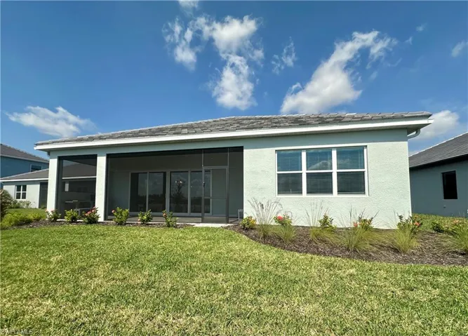 Back of property featuring stucco siding, a yard, and a sunroom