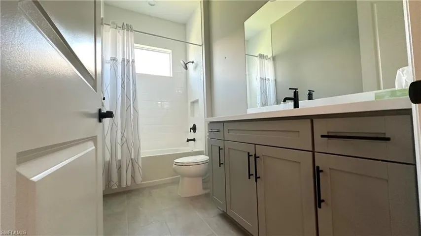 Full bathroom with shower / bathtub combination with curtain and vanity