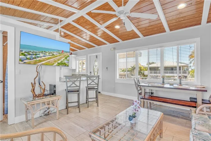 Living area featuring wood ceiling, a ceiling fan, wood tiled floors, and lofted ceiling with beams
