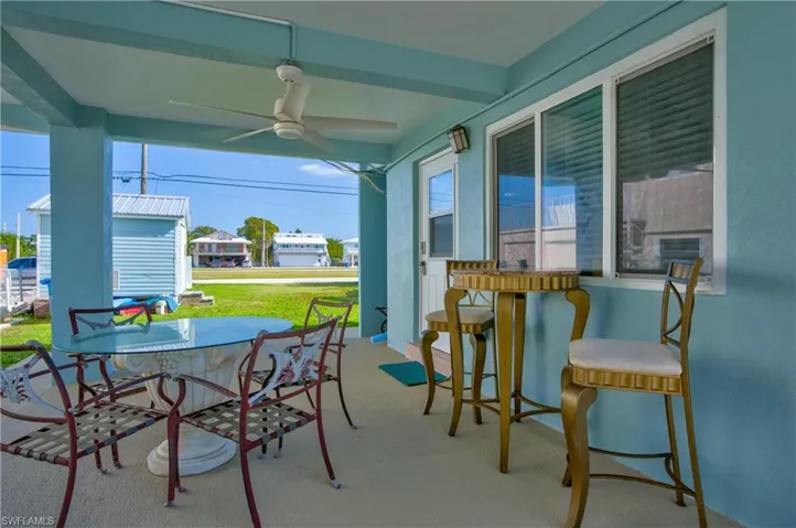 View of patio / terrace with ceiling fan, outdoor dining space, a residential view, and an outdoor structure