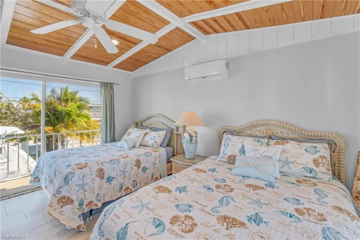 Bedroom with a vaulted wood ceiling, access to exterior, wood finished floors, and a ceiling fan