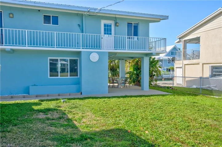 Rear view of property with a patio area, stucco siding, and a balcony