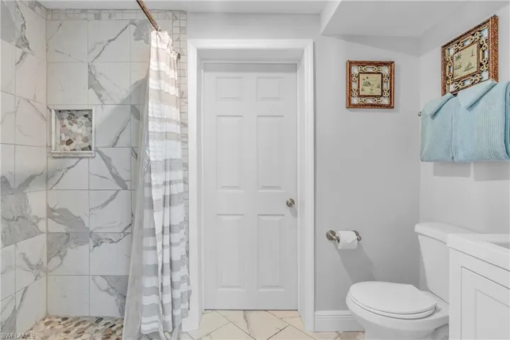 Bathroom with vanity, a stall shower, and light marble finish flooring