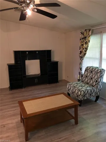 Living room with ceiling fan and wood-type flooring