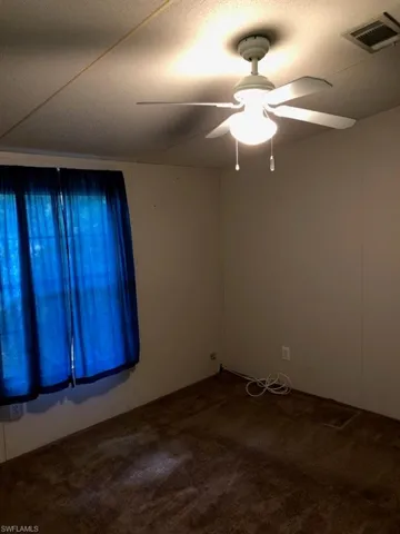 Empty room featuring carpet floors and ceiling fan