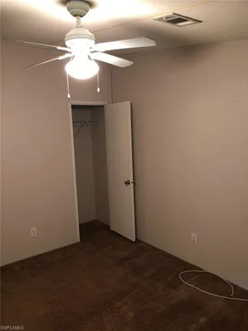 Unfurnished bedroom featuring a closet, ceiling fan, and carpet flooring