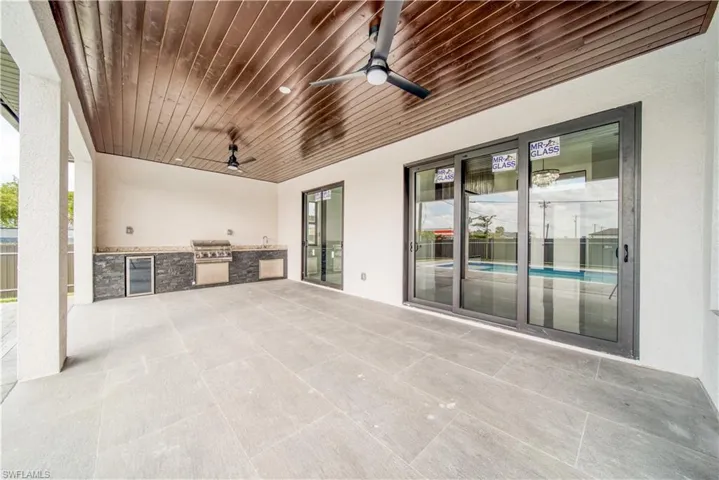 View of patio / terrace with an outdoor kitchen, area for grilling, beverage cooler, and ceiling fan