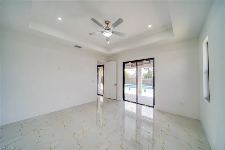 Spare room with a raised ceiling and ceiling fan