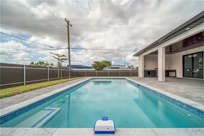 View of pool featuring a patio area, ceiling fan, and exterior kitchen