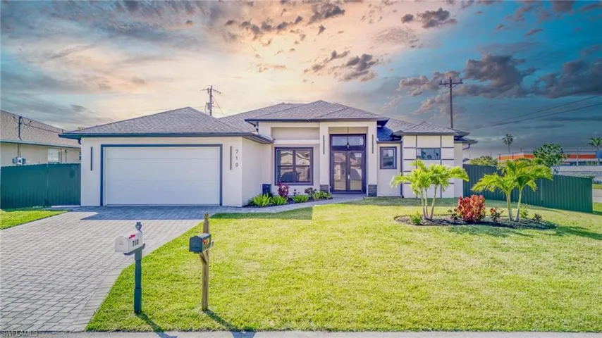 View of front of home featuring a garage and a yard