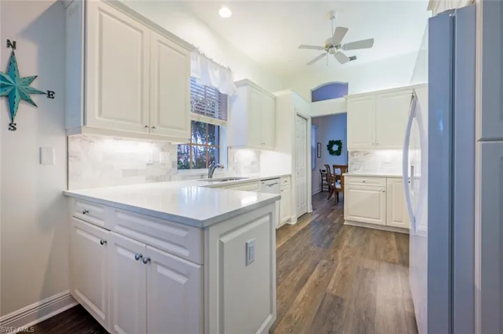 Kitchen with white cabinetry, quartz counter top and tile backsplash