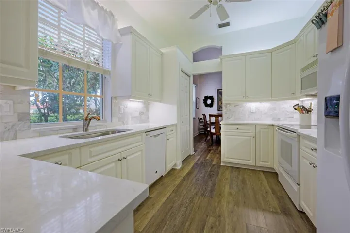 Kitchen featuring white appliances, ceiling fan and lots of natural light through the good size window.