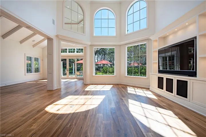 lLiving room featuring natural light, wood flooring and high ceilings