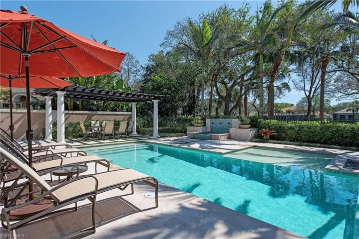View of swimming pool featuring the patio area and pergola with golf views