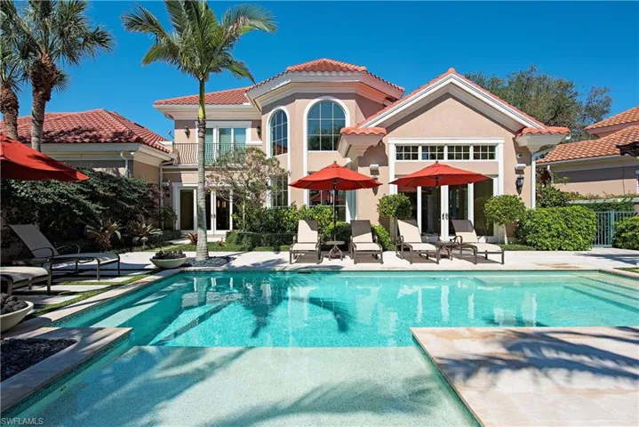 Back of property featuring an expansive patio area and beautiful pool