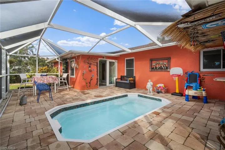 View of swimming pool featuring a lanai and a patio area